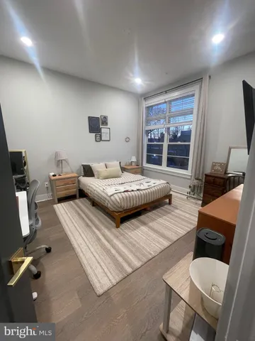 a bedroom with a bed a couch and large window