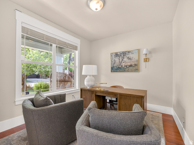 557 Craftsman Way Midway, UT 84049 - Photo 6 of 59 Bright room featuring wood-finish flooring, a large window with white trim, a built-in wall sconce, and a ceiling-mounted light fixture