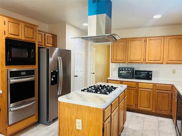 a kitchen with stainless steel appliances granite countertop a refrigerator and a stove top oven