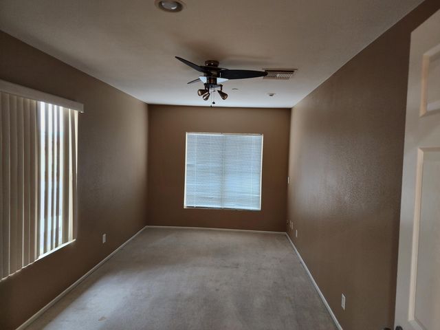 an empty room with a window and a ceiling fan