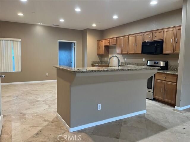a kitchen with stainless steel appliances granite countertop a sink a stove and cabinets