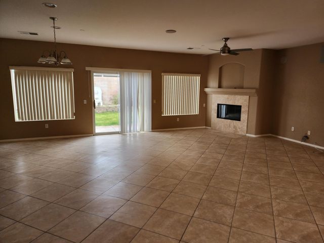 an empty room with windows and fireplace