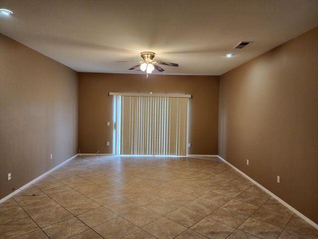 a view of an empty room with a chandelier fan