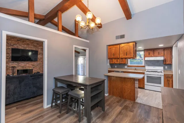 a kitchen with stainless steel appliances granite countertop a stove a sink and a refrigerator