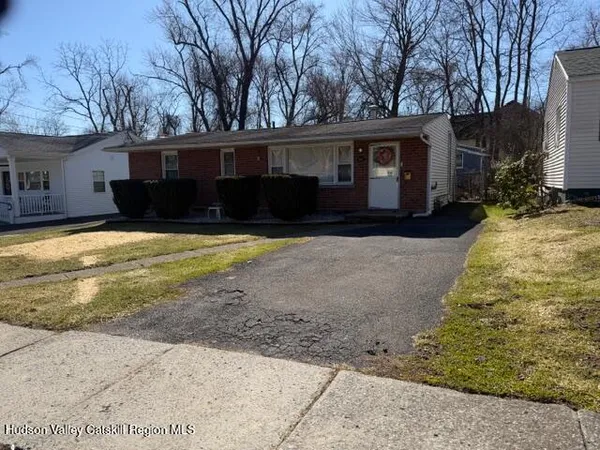 a front view of house with yard and trees in the background