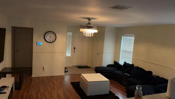 a living room with furniture and wooden floor