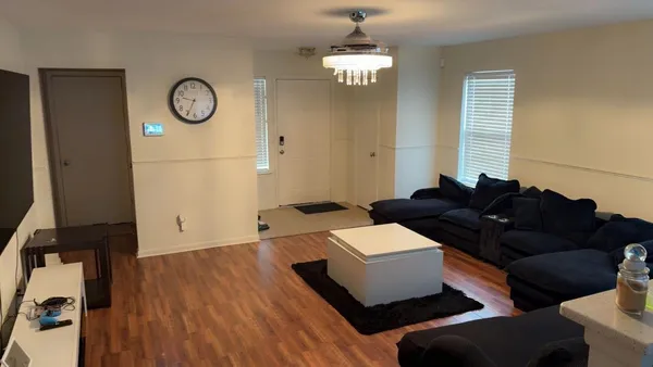 a living room with furniture a clock on wall and a window