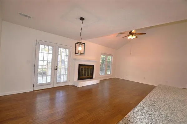 a view of an empty room with a fireplace and a window