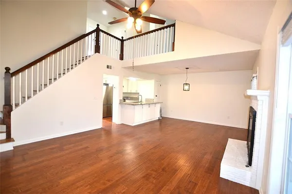 a view of a hallway with wooden floor and staircase
