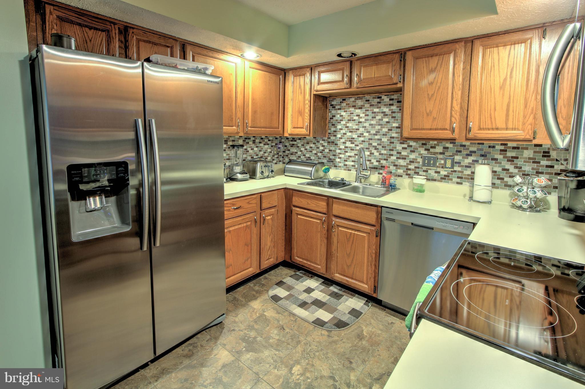 704 Streamside Drive Bowie, MD 20721 - Photo 5 of 24 a kitchen with a sink refrigerator and cabinets