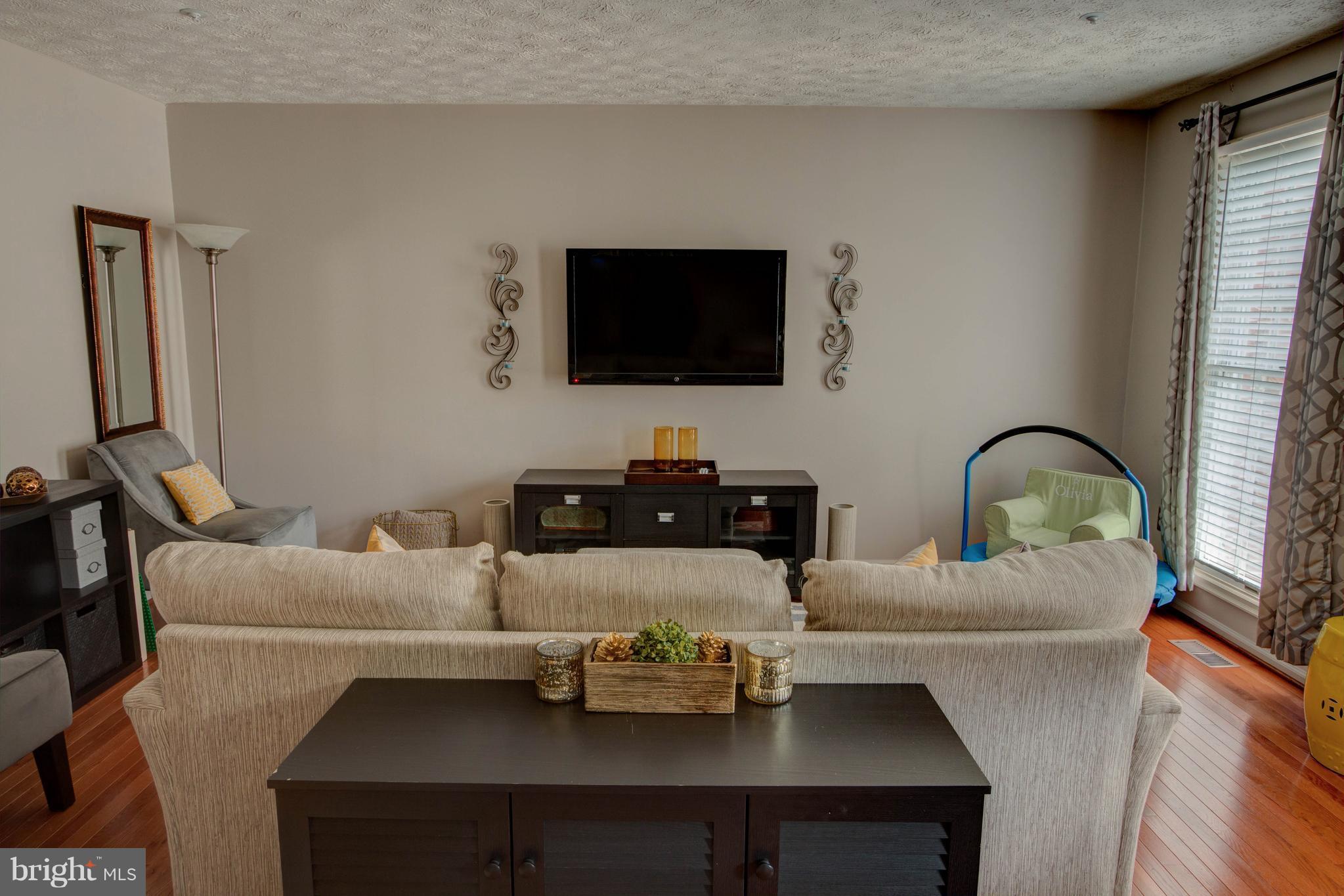 704 Streamside Drive Bowie, MD 20721 - Photo 10 of 24 a living room with furniture and a flat screen tv