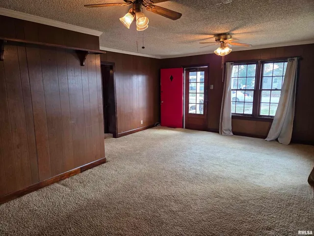 an empty room with windows and fan