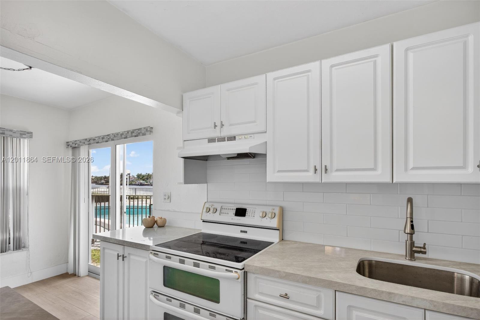 615 South Riverside Drive, Unit 5 Pompano Beach, FL 33062 - Photo 15 of 29 a kitchen with white cabinets and appliances