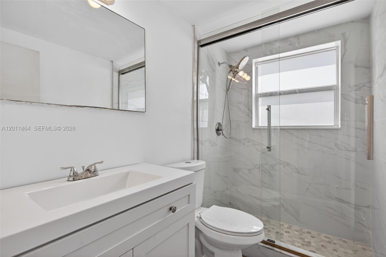 615 South Riverside Drive, Unit 5 Pompano Beach, FL 33062 - Photo 19 of 29 a bathroom with a sink toilet a mirror and shower