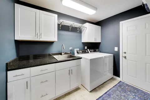 a kitchen with granite countertop a sink a stove and cabinets