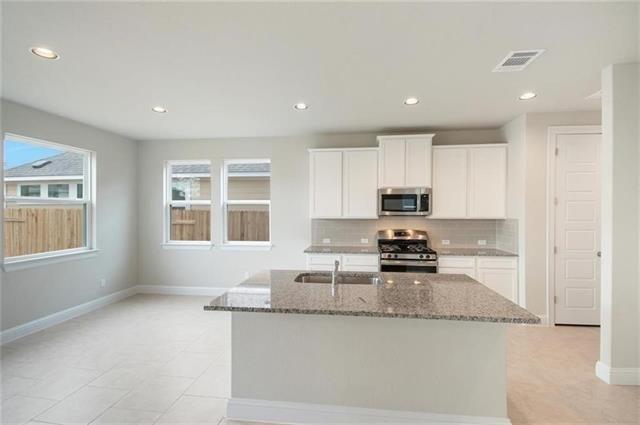 113 Gaida Loop Georgetown, TX 78628 - Photo 11 of 23 Kitchen featuring dark stone countertops, white cabinets, decorative backsplash, stainless steel appliances, and recessed lighting