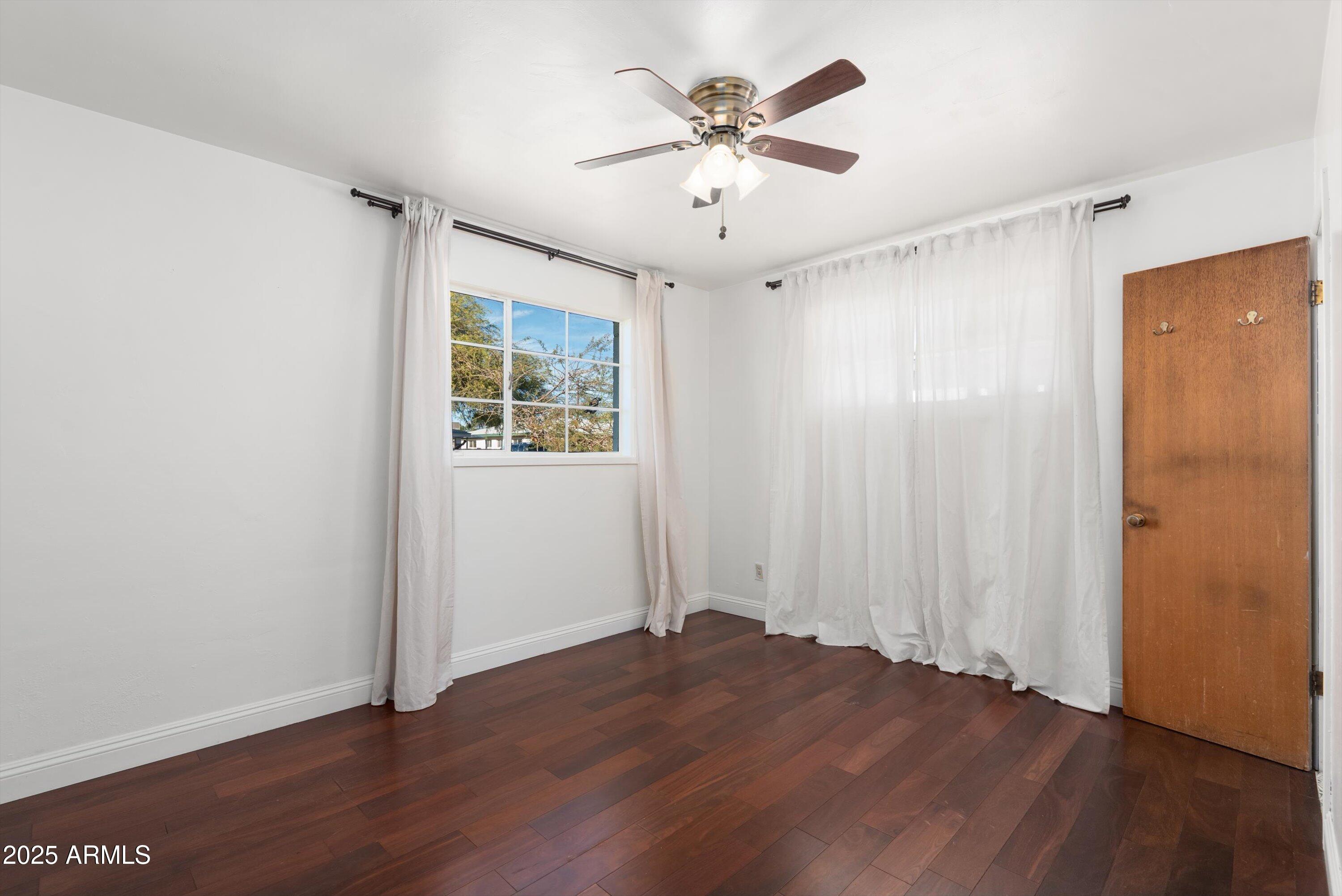 2217 West Gardenia Drive Phoenix, AZ 85021 - Photo 12 of 32 an empty room with wooden floor and windows