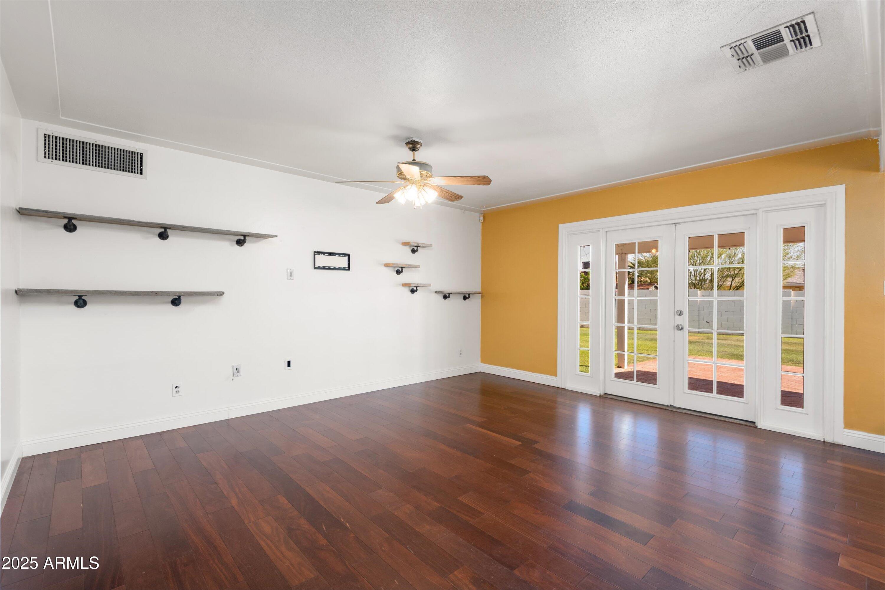 2217 West Gardenia Drive Phoenix, AZ 85021 - Photo 5 of 32 a view of an empty room with a window and wooden floor