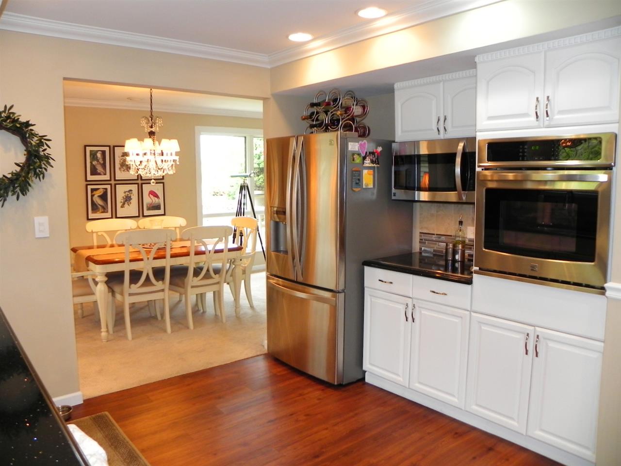 512 Baintree Road Lake Summerset, IL 61019 - Photo 20 of 25 a kitchen with stainless steel appliances granite countertop a refrigerator a oven a sink a dining table and chairs with wooden floor