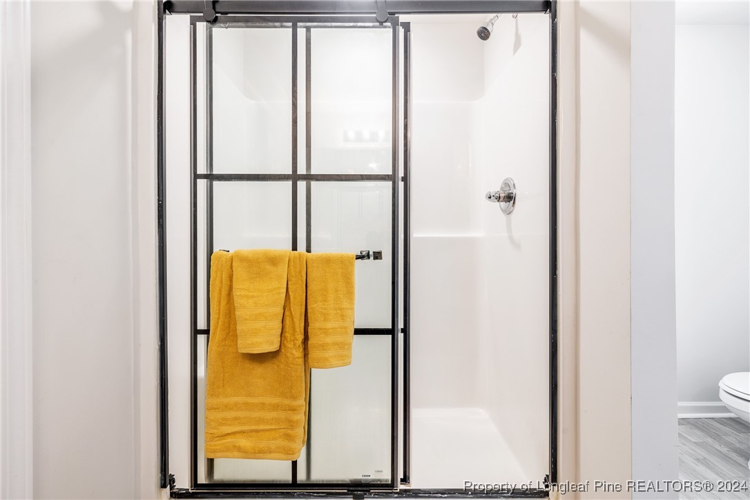 5918 Lowgrass Road Stedman, NC 28391 - Photo 29 of 32 a bathroom with a granite countertop shower and a toilet