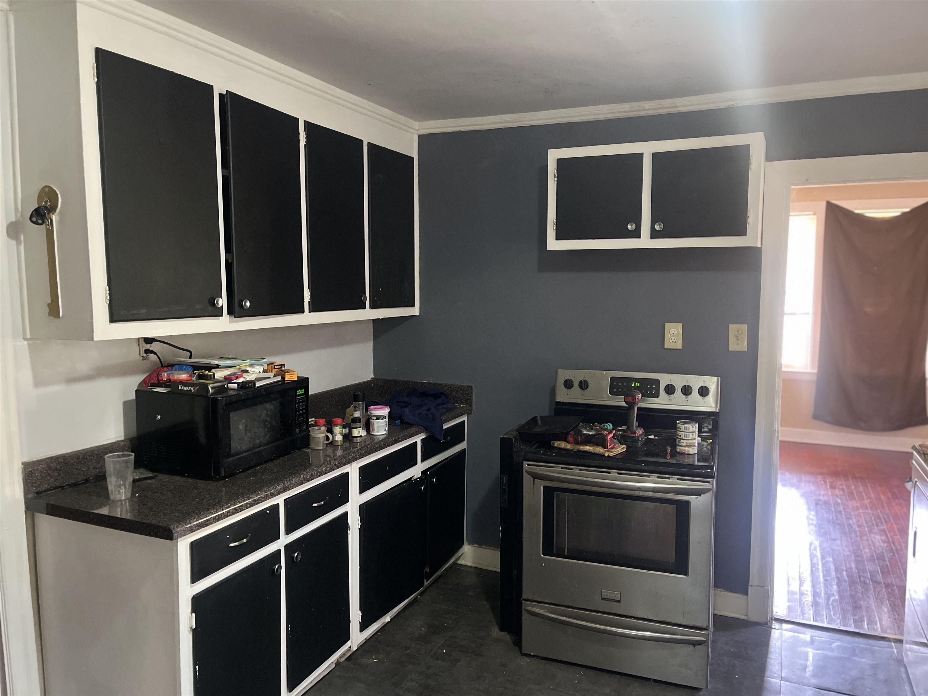 3382 Ardmore Street Memphis, TN 38127 - Photo 3 of 6 Kitchen featuring ornamental molding, dark stone countertops, black microwave, stainless steel range with electric stovetop, and dark cabinetry