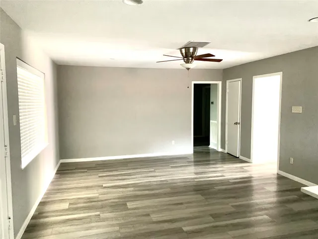 a view of a livingroom with a ceiling fan and window