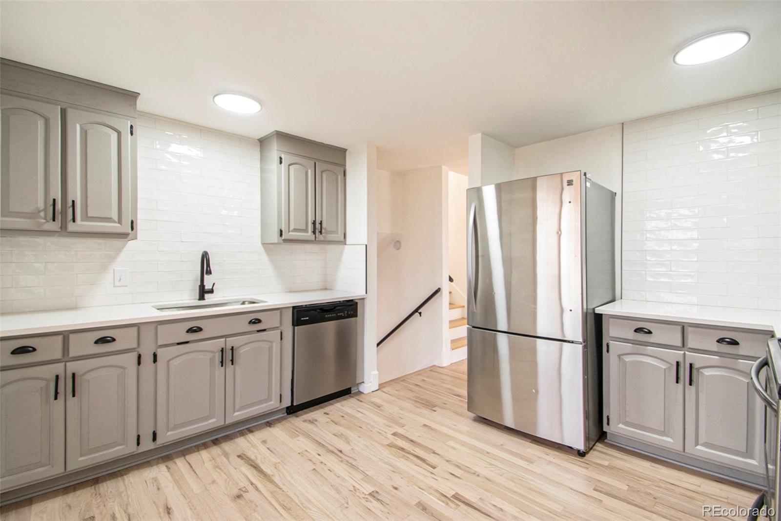 8360 Emerson Street Denver, CO 80229 - Photo 3 of 13 a kitchen with stainless steel appliances granite countertop a refrigerator sink and cabinets