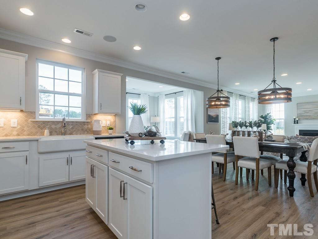 104 Red Cardinal Way Angier, NC 27501 - Photo 11 of 26 a kitchen with lots of counter top space sink stove and wooden floor