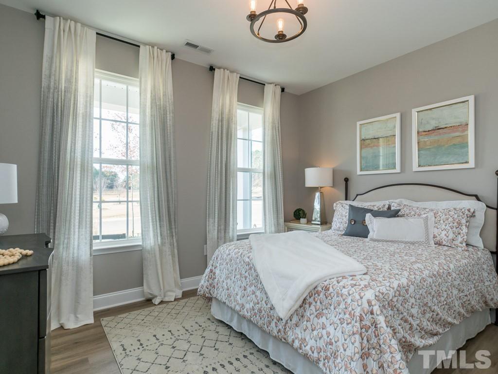 104 Red Cardinal Way Angier, NC 27501 - Photo 13 of 26 a bedroom with a large bed and a window