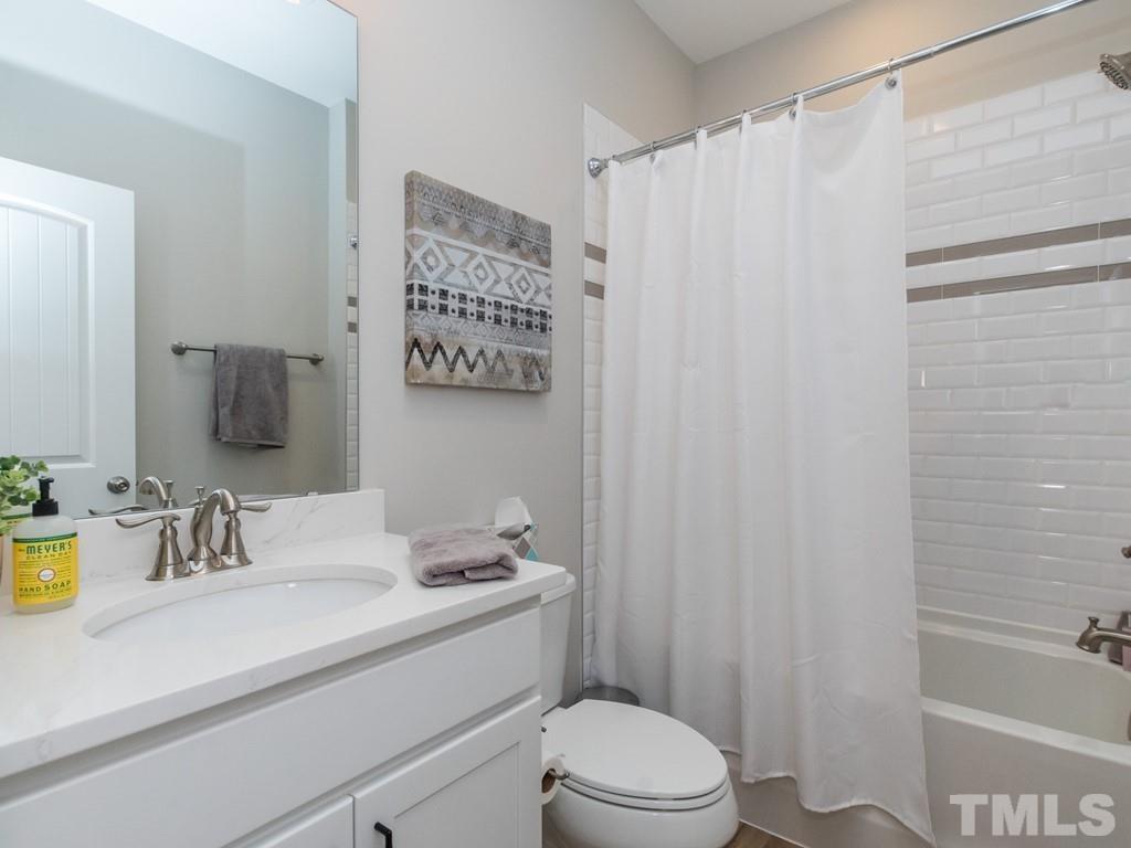 104 Red Cardinal Way Angier, NC 27501 - Photo 14 of 26 a bathroom with a sink a toilet and shower curtain