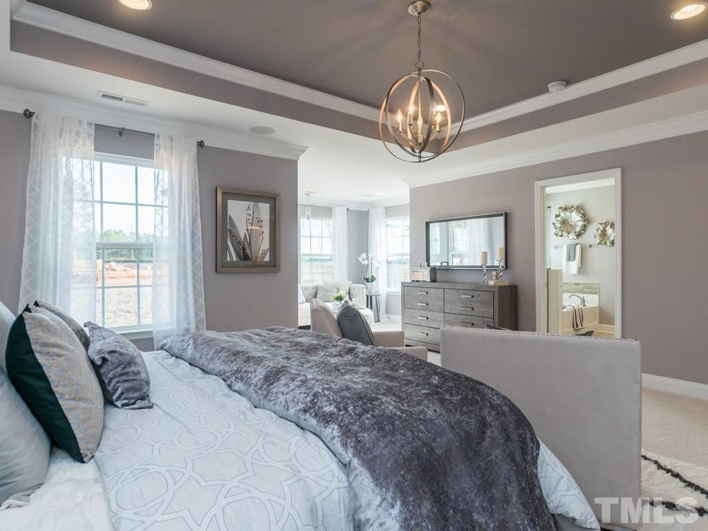 104 Red Cardinal Way Angier, NC 27501 - Photo 17 of 26 a large bedroom with a large bed and wooden floor