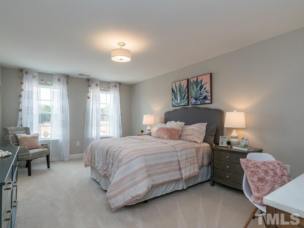 104 Red Cardinal Way Angier, NC 27501 - Photo 22 of 26 a bedroom with a bed and furniture