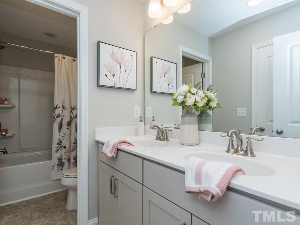 104 Red Cardinal Way Angier, NC 27501 - Photo 23 of 26 a bathroom with a bathtub sink and mirror