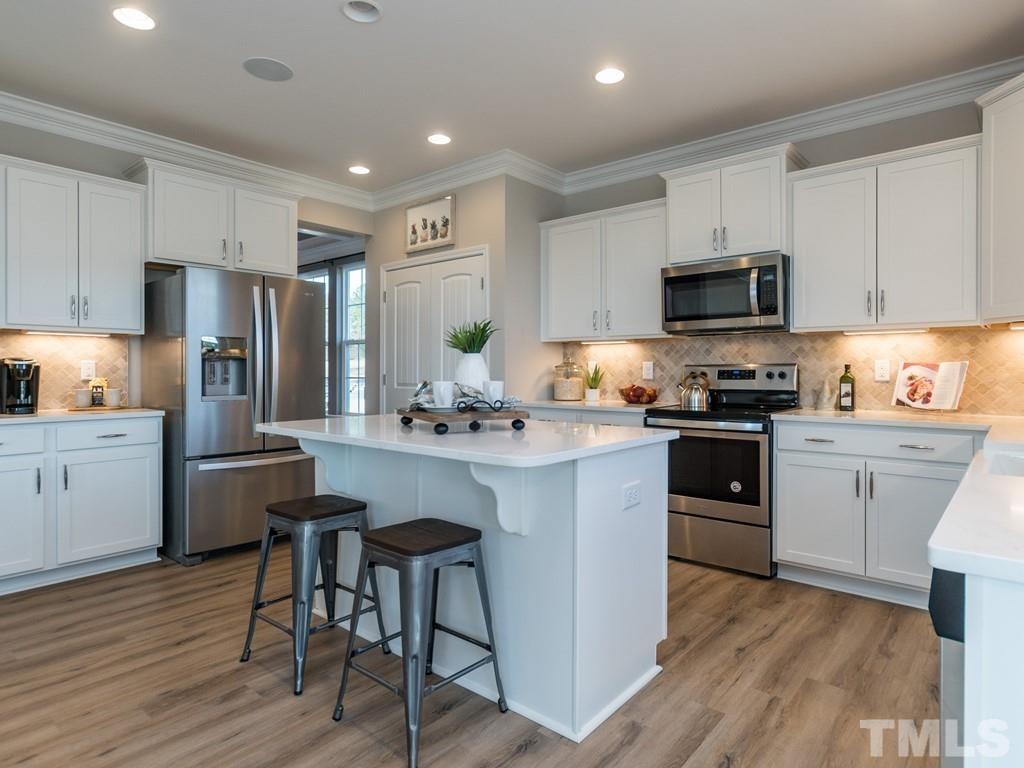 104 Red Cardinal Way Angier, NC 27501 - Photo 9 of 26 a kitchen with granite countertop a refrigerator stove top oven and sink