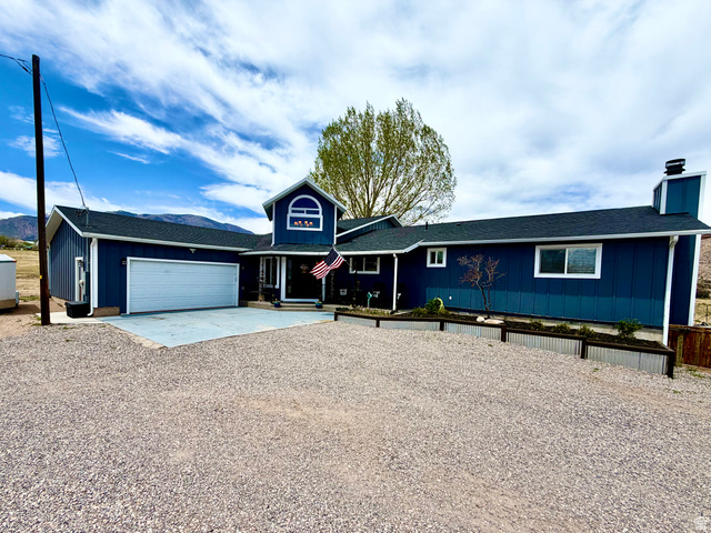656 South Bullion Canyon Road Marysvale, UT 84750 - Photo 56 of 57 Navy blue exterior siding with white trim, a prominent two-car garage, and a gravel driveway