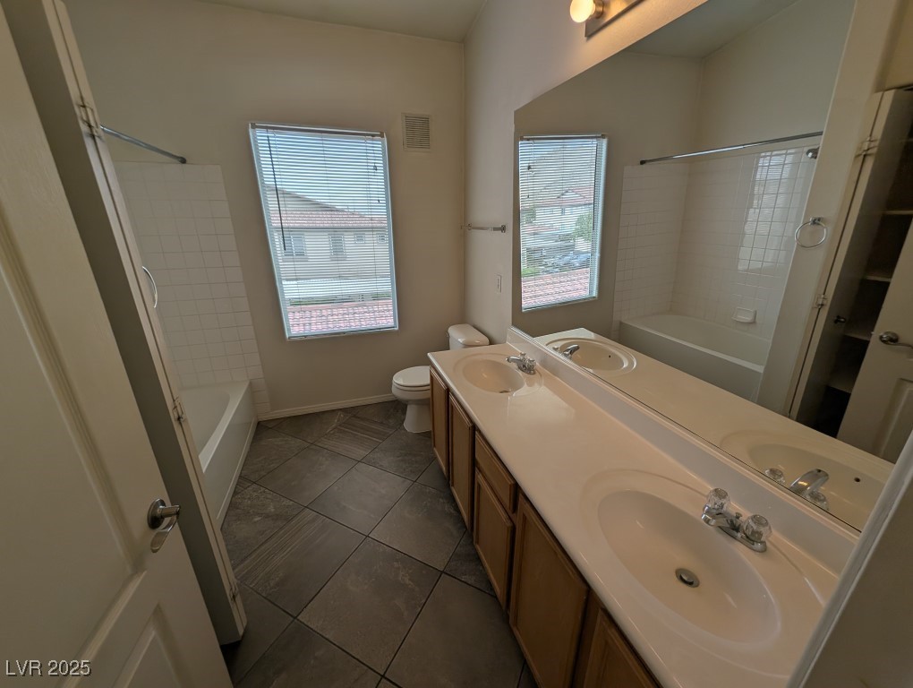 3504 Desert Cliff Street, Unit 203 Las Vegas, NV 89129 - Photo 13 of 20 Full bath featuring bathing tub / shower combination, double vanity, toilet, and tile patterned floors