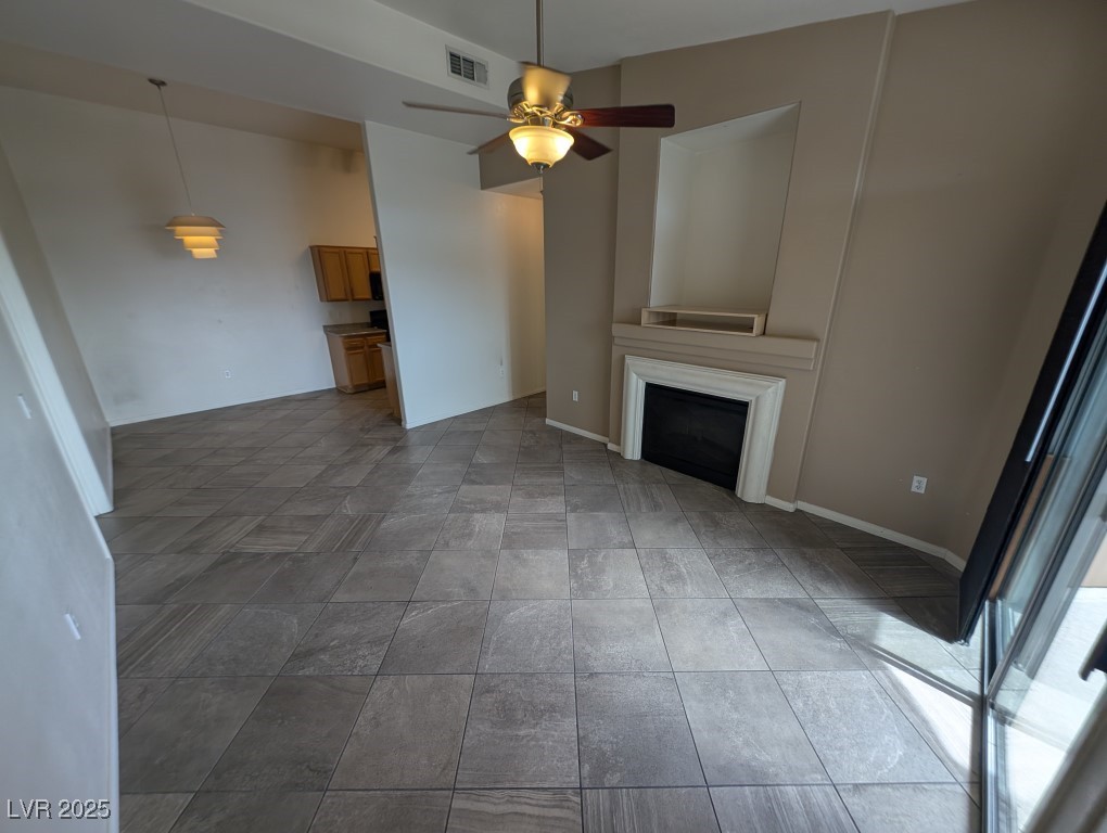 3504 Desert Cliff Street, Unit 203 Las Vegas, NV 89129 - Photo 2 of 20 Unfurnished living room featuring a fireplace, ceiling fan, and baseboards