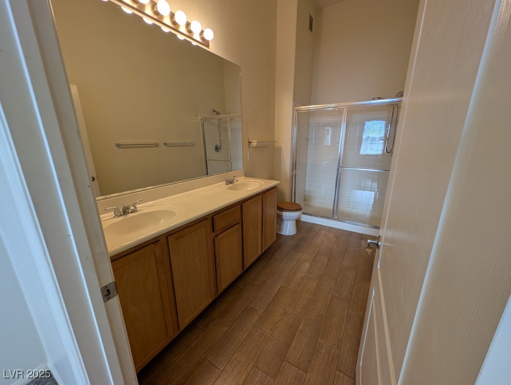 3504 Desert Cliff Street, Unit 203 Las Vegas, NV 89129 - Photo 9 of 20 Full bathroom with wood finished floors, double vanity, a shower stall, and toilet