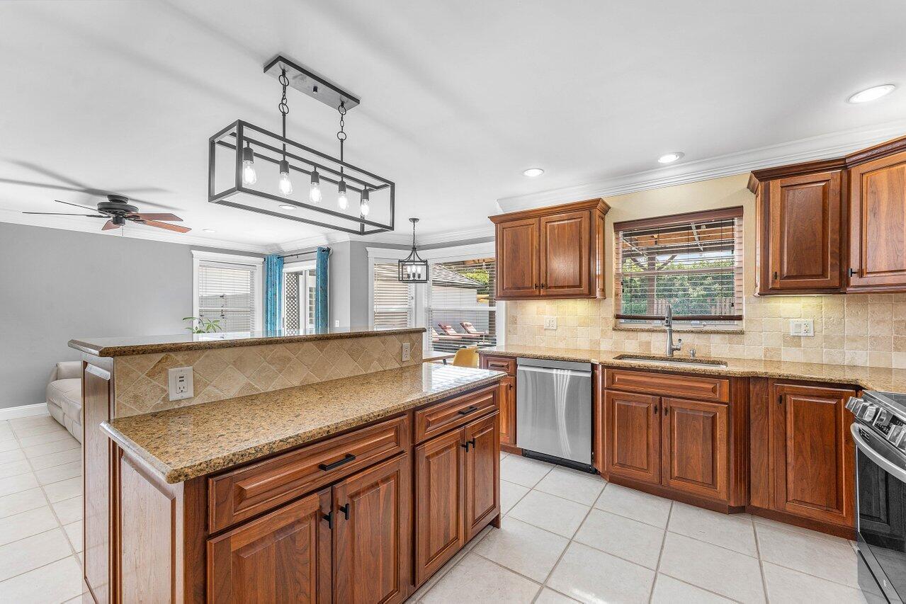 9434 Fox Trot Lane Boca Raton, FL 33496 - Photo 16 of 66 a kitchen with stainless steel appliances granite countertop a sink and stove top oven