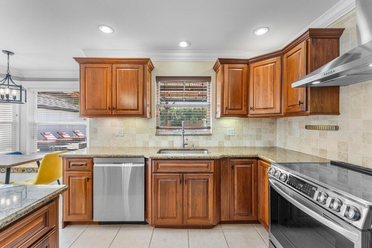 9434 Fox Trot Lane Boca Raton, FL 33496 - Photo 17 of 66 a kitchen with stainless steel appliances granite countertop a stove a sink and a microwave