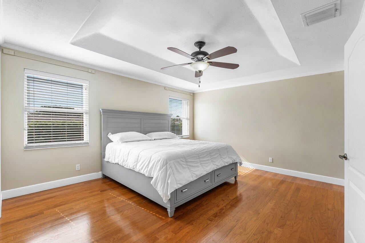 9434 Fox Trot Lane Boca Raton, FL 33496 - Photo 22 of 66 a spacious bedroom with a bed and a window