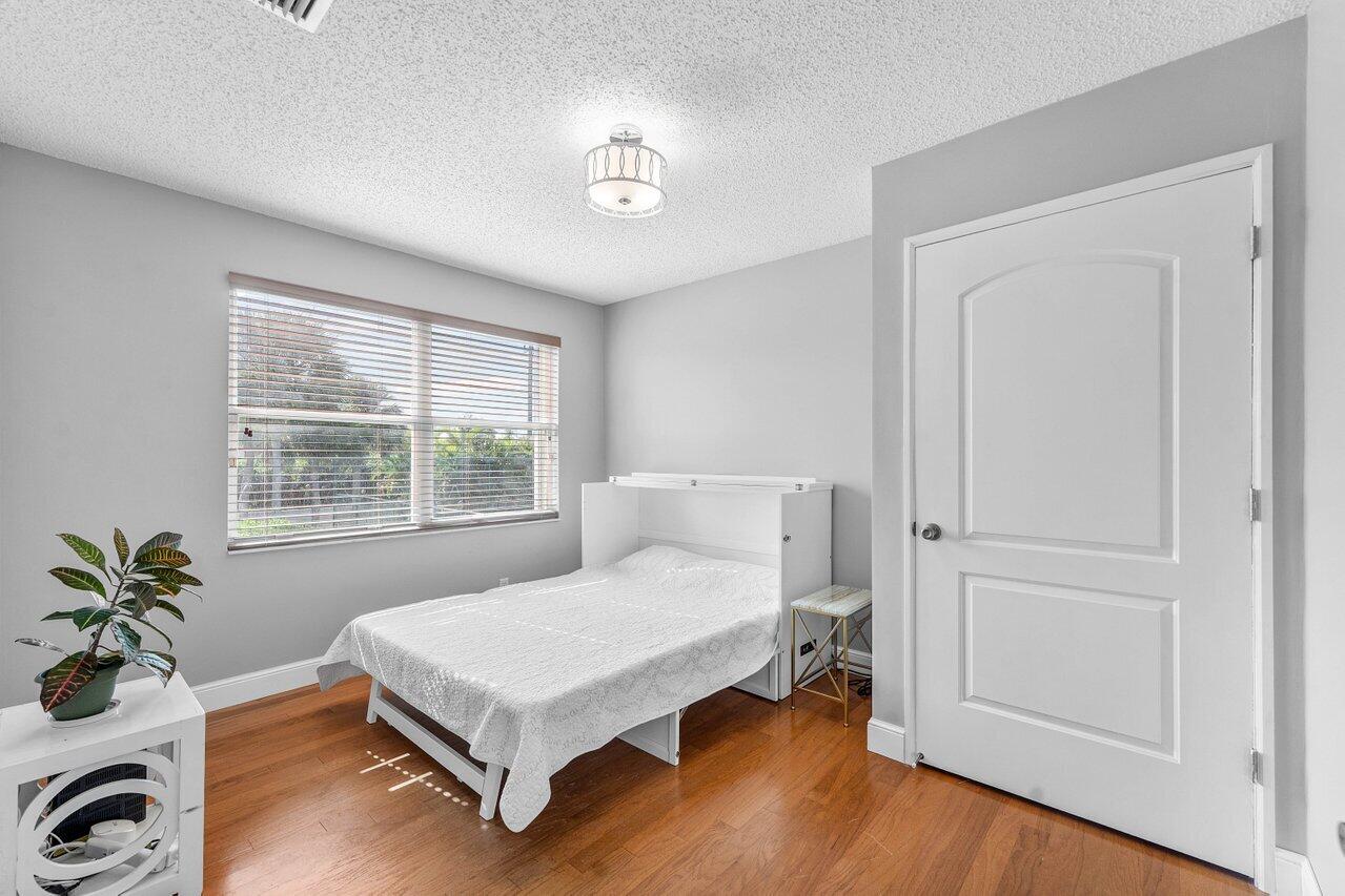 9434 Fox Trot Lane Boca Raton, FL 33496 - Photo 27 of 66 a bedroom with a bed window and a potted plant