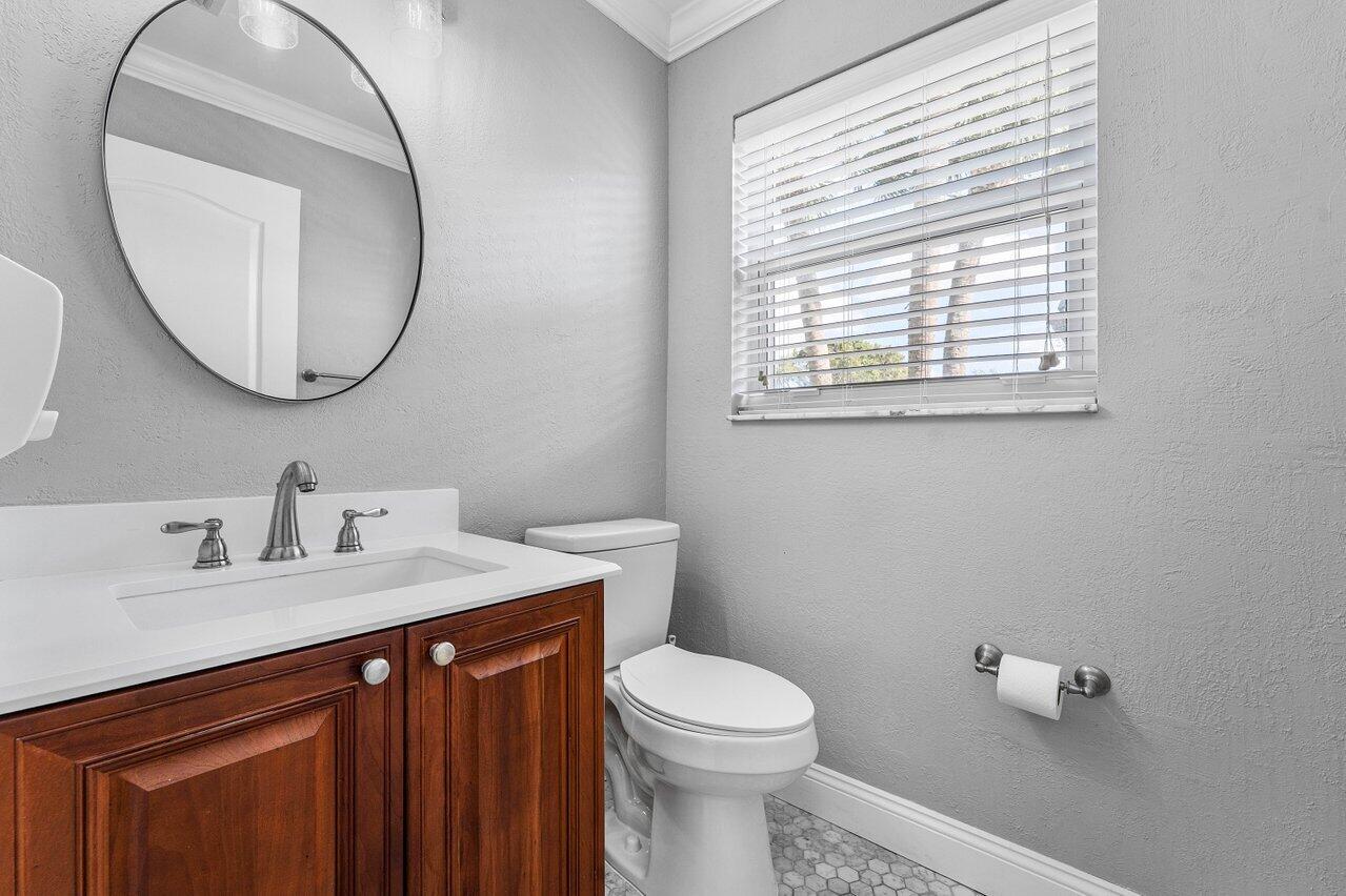9434 Fox Trot Lane Boca Raton, FL 33496 - Photo 29 of 66 a bathroom with a toilet a sink a mirror and a window