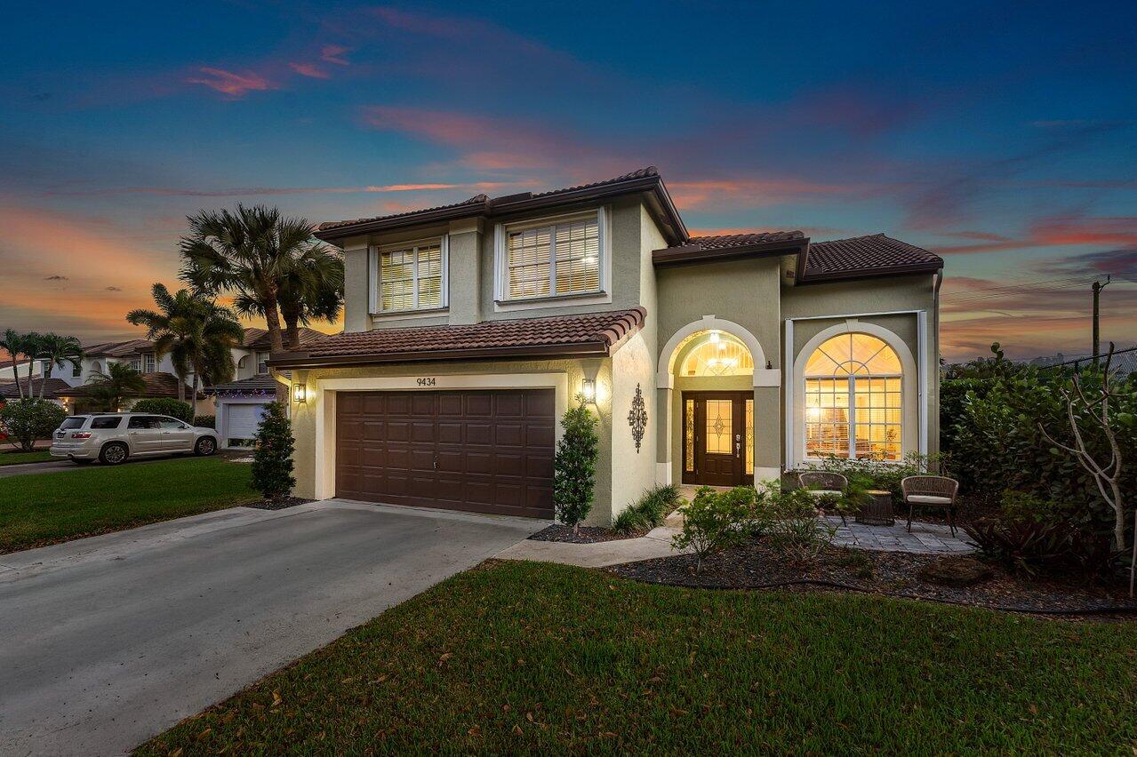 9434 Fox Trot Lane Boca Raton, FL 33496 - Photo 47 of 66 a brick house with a clock on the side of it with garden