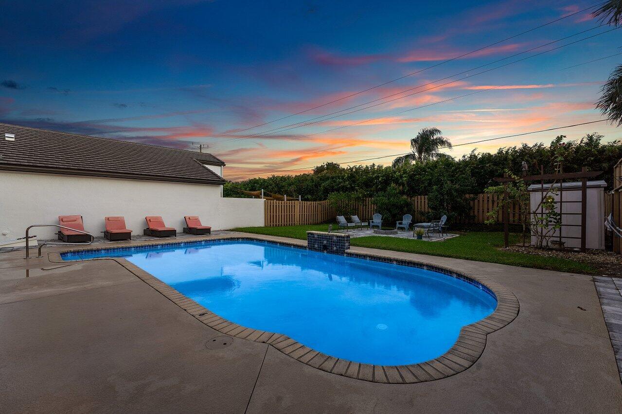 9434 Fox Trot Lane Boca Raton, FL 33496 - Photo 57 of 66 a view of a swimming pool with an outdoor seating and a garden