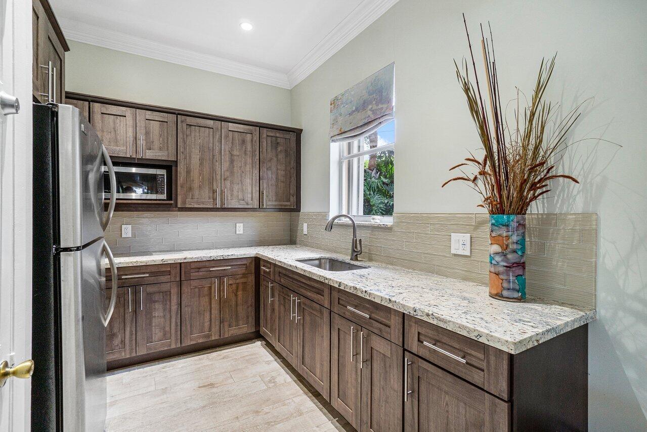 9434 Fox Trot Lane Boca Raton, FL 33496 - Photo 61 of 66 a kitchen with stainless steel appliances granite countertop a sink stove and refrigerator