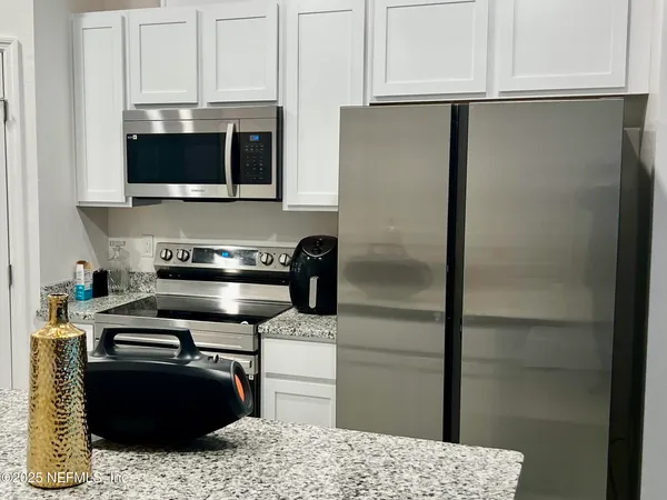 a kitchen with stainless steel appliances granite countertop a refrigerator and a stove top oven