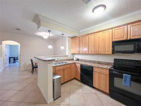 a kitchen with stainless steel appliances granite countertop a stove top oven a sink dishwasher and a refrigerator