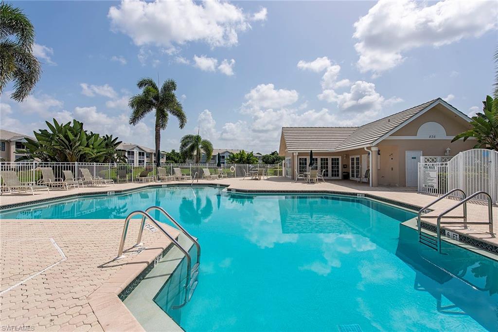 841 Tanbark Drive, Unit 202 Naples, FL 34108 - Photo 12 of 12 a view of a swimming pool with a lounge chairs