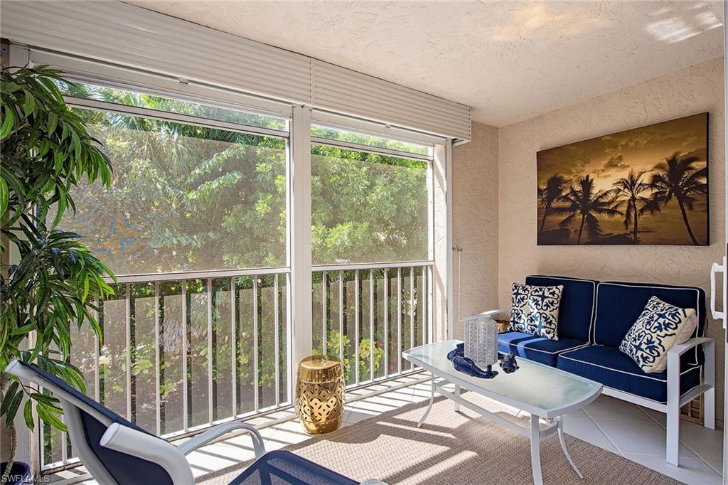 841 Tanbark Drive, Unit 202 Naples, FL 34108 - Photo 10 of 12 a living room with furniture and a floor to ceiling window